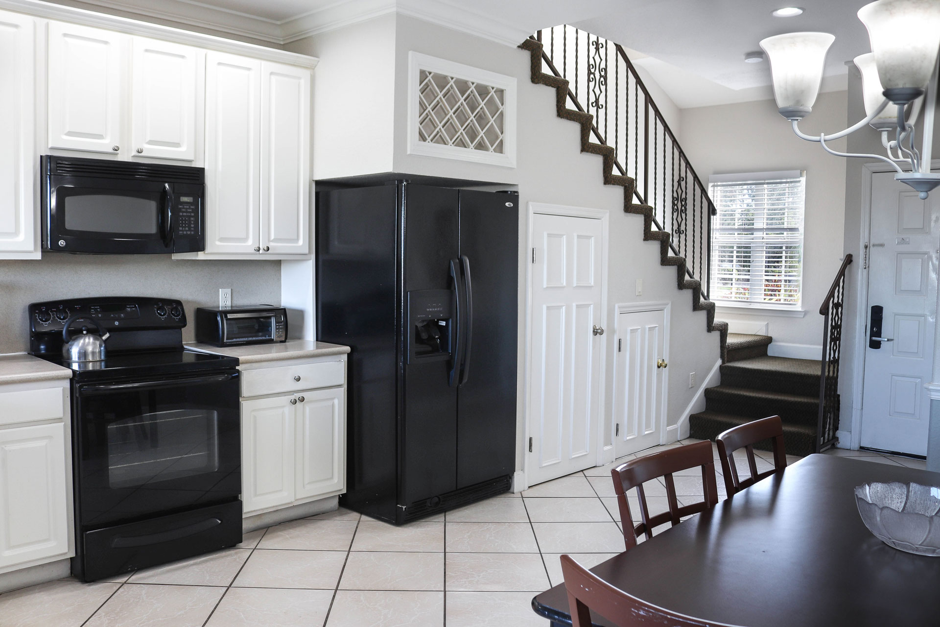 A kitchen with a dining area and staircase